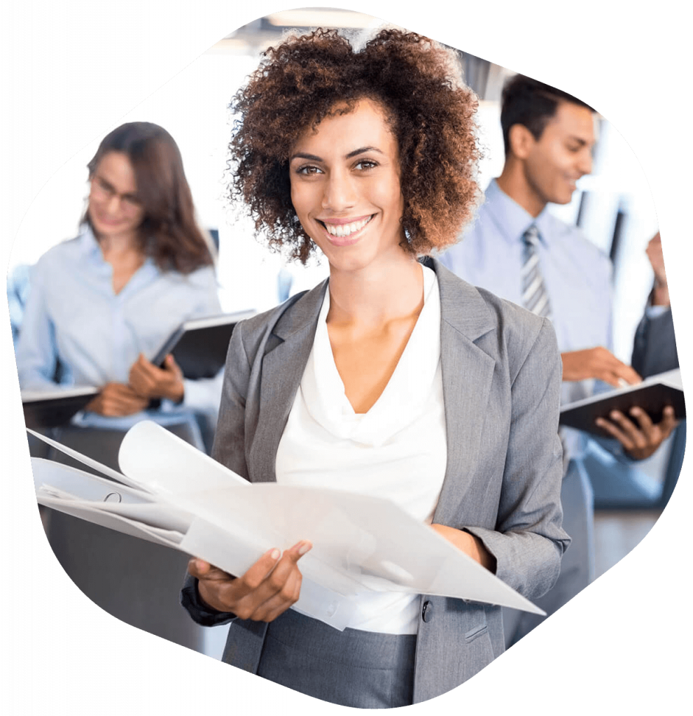 Mujer de negocios mira a cámara rodeada de su equipo